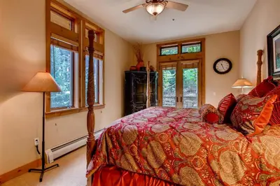a bedroom with a bed and a clock on the wall at Premier 3 Bedroom Timbers Ski In, Ski Out Vacation Rental At The Timbers With The Best Access To Skiing In Keystone in Keystone