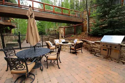 a patio with a table and chairs and a grill at Premier 3 Bedroom Timbers Ski In, Ski Out Vacation Rental At The Timbers With The Best Access To Skiing In Keystone in Keystone