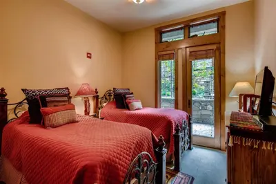 a bedroom with two beds with red sheets and a window at Premier 3 Bedroom Timbers Ski In, Ski Out Vacation Rental At The Timbers With The Best Access To Skiing In Keystone in Keystone