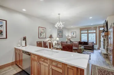 a kitchen with a white counter top and a living room at Premier 1 Bedroom Ski In, Ski Out Lone Eagle Condo With The Best Access To Skiing In Keystone in Keystone