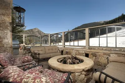 a patio with a fire pit and a view of a mountain at Premier 1 Bedroom Ski In, Ski Out Lone Eagle Condo With The Best Access To Skiing In Keystone in Keystone