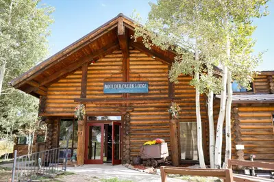 a log cabin with a sign on the front of it at The Boulder Creek Lodge in Nederland