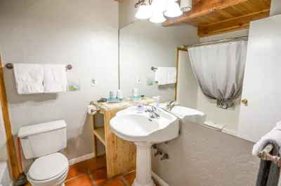 a bathroom with a sink and a toilet and a mirror at The Boulder Creek Lodge in Nederland