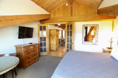 a bedroom with a bed and a flat screen tv at The Boulder Creek Lodge in Nederland