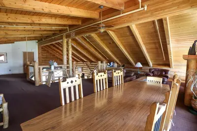 a dining room with a large wooden table and chairs at The Boulder Creek Lodge in Nederland