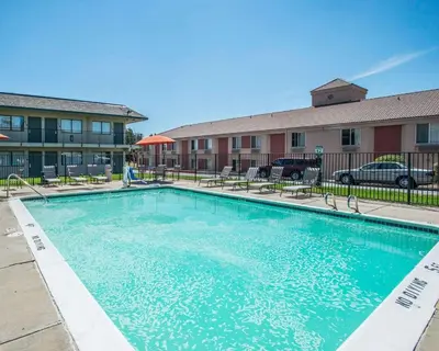 a large swimming pool in front of a building at Rodeway Inn Greeley in Evans