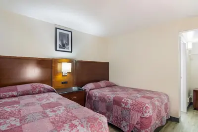 a hotel room with two beds and a window at Rodeway Inn Greeley in Evans