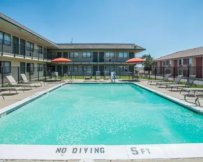a pool with chairs and a no driving sign in front of a building at Rodeway Inn Greeley in Evans