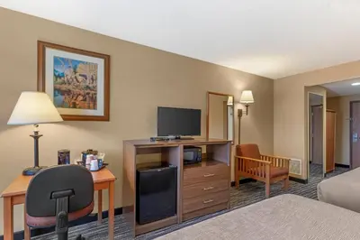 a hotel room with a bed and a desk with a television at Quality Inn & Suites Wellington - Fort Collins in Wellington