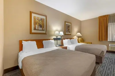 a hotel room with two beds and a window at Quality Inn & Suites Wellington - Fort Collins in Wellington