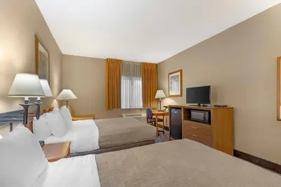 a hotel room with two beds and a flat screen tv at Quality Inn & Suites Wellington - Fort Collins in Wellington