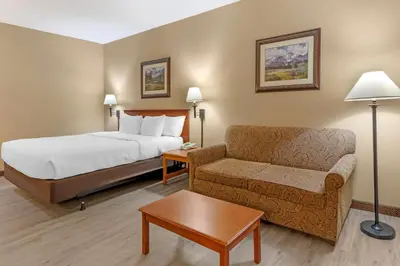 a hotel room with a bed and a couch at Quality Inn & Suites Wellington - Fort Collins in Wellington