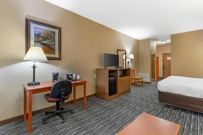 a hotel room with a bed and a desk with a computer at Quality Inn & Suites Wellington - Fort Collins in Wellington