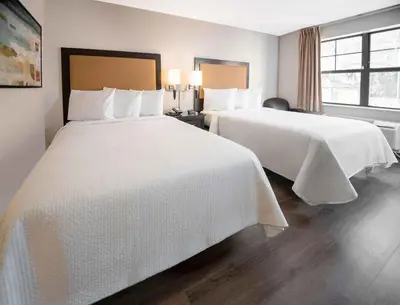 a hotel room with two beds with white sheets at Extended Stay America Suites - Denver - Westminster in Westminster