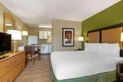 a hotel room with a large bed and a kitchen at Extended Stay America Select Suites - Denver - Cherry Creek in Denver