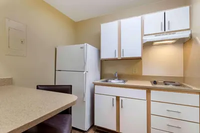 a kitchen with white cabinets and a white refrigerator at Extended Stay America Select Suites - Denver - Cherry Creek in Denver