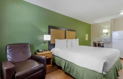 a hotel room with a bed and a chair at Extended Stay America Select Suites - Denver - Cherry Creek in Denver