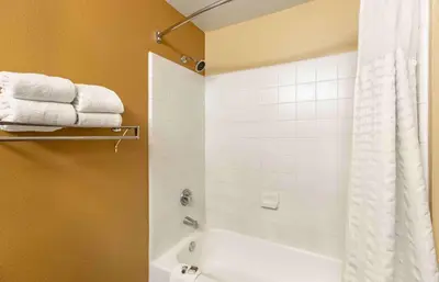 a bathroom with a tub and a shower with towels at Extended Stay America Select Suites - Denver - Cherry Creek in Denver