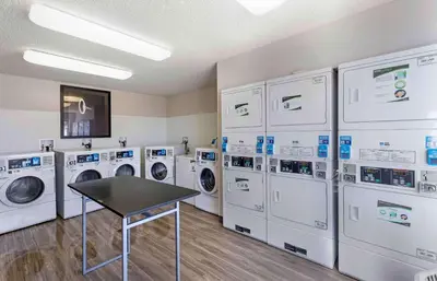 a laundry room with washing machines and a table at Extended Stay America Select Suites - Denver - Cherry Creek in Denver