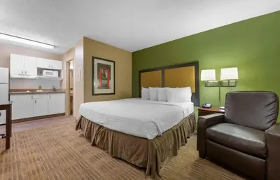 a hotel room with a bed and a chair at Extended Stay America Select Suites - Denver - Lakewood South in Lakewood