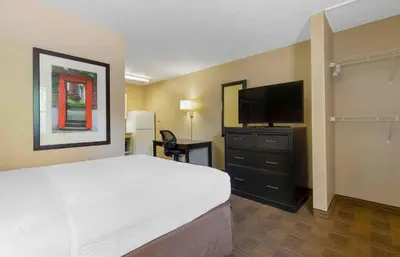 a hotel room with a bed and a flat screen tv at Extended Stay America Select Suites - Denver - Lakewood South in Lakewood