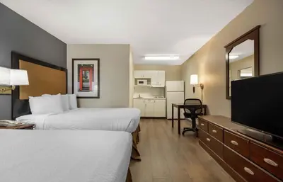 a hotel room with two beds and a flat screen tv at Extended Stay America Select Suites - Denver - Lakewood South in Lakewood