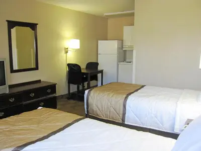 a hotel room with two beds and a mirror at Extended Stay America Select Suites - Denver - Lakewood South in Lakewood