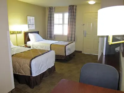 a hotel room with two beds and a tv at Extended Stay America Select Suites - Denver - Lakewood South in Lakewood