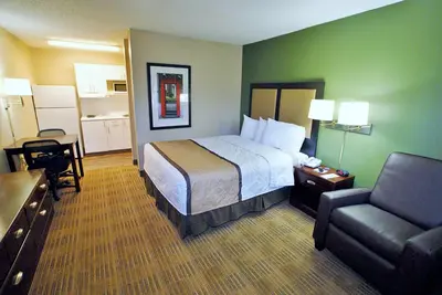 a hotel room with a bed and a chair at Extended Stay America Select Suites - Denver - Lakewood South in Lakewood