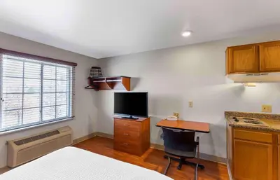 a bedroom with a bed and a desk with a television at Extended Stay America Select Suites - Denver - Aurora in Aurora