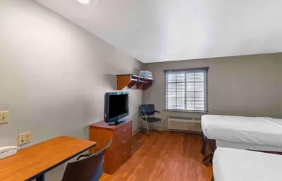 a bedroom with a bed and a desk with a television at Extended Stay America Select Suites - Denver - Aurora in Aurora
