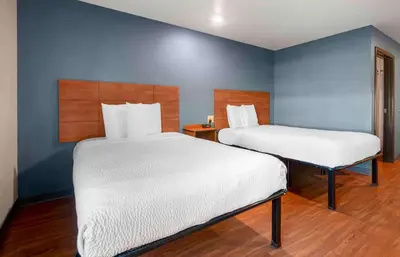 two beds in a room with blue walls at Extended Stay America Select Suites - Denver - Aurora in Aurora