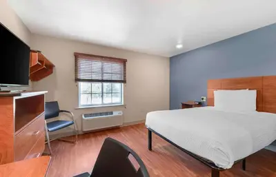 a bedroom with a large bed and a television at Extended Stay America Select Suites - Denver - Aurora in Aurora