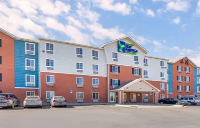 a large building with cars parked in a parking lot at Extended Stay America Select Suites - Denver - Aurora in Aurora
