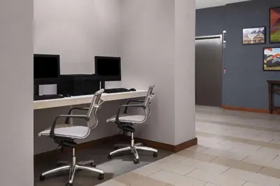 an office with two chairs and a desk with a computer at Hyatt House Boulder/Broomfield in Broomfield