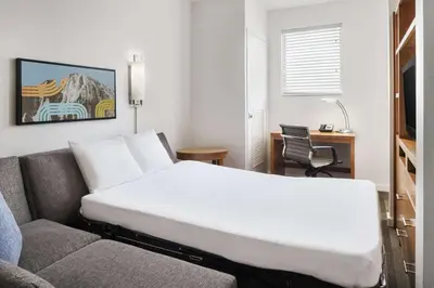 a bed in a room next to a couch at Hyatt House Boulder/Broomfield in Broomfield