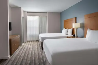 a hotel room with two beds and a television at Hyatt House Boulder/Broomfield in Broomfield