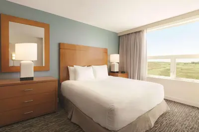 a bedroom with a large bed and a large window at Hyatt House Denver Airport in Denver