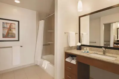 a bathroom with a sink and a mirror and a tub at Hyatt House Denver Airport in Denver