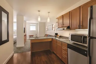 a kitchen with wooden cabinets and a microwave at Hyatt House Denver Airport in Denver