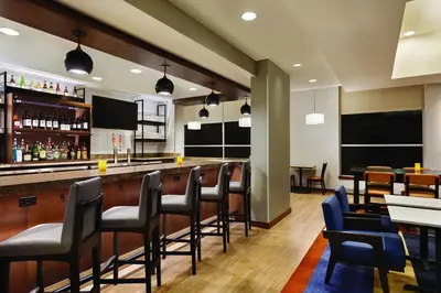 a bar in a restaurant with black chairs at Hyatt House Denver Airport in Denver