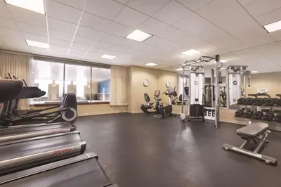 a gym with treadmills and machines in a room at Hyatt House Denver Airport in Denver