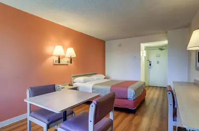 a hotel room with a bed and a table and chairs at Motel 6-Greenwood Village, CO - Denver - South Tech Center in Greenwood Village