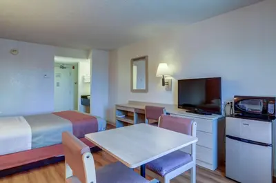 a hotel room with two beds and a table and a television at Motel 6-Greenwood Village, CO - Denver - South Tech Center in Greenwood Village