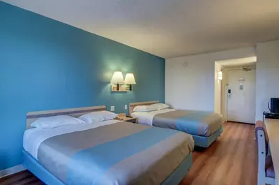 two beds in a hotel room with blue walls at Motel 6-Greenwood Village, CO - Denver - South Tech Center in Greenwood Village