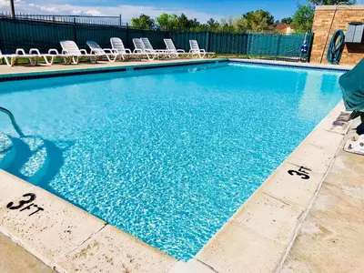 a large swimming pool with chairs and blue water at Motel 6-Greenwood Village, CO - Denver - South Tech Center in Greenwood Village