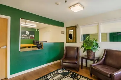 a waiting room with two chairs and a green wall at HomeTowne Studios by Red Roof Denver - Glendale/ Cherry Creek in Denver