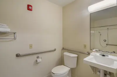 a bathroom with a toilet and a sink and a mirror at HomeTowne Studios by Red Roof Denver - Glendale/ Cherry Creek in Denver