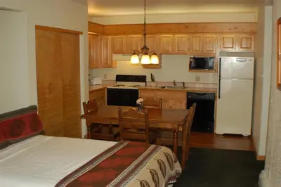 a kitchen with a table and a kitchen with a bed at Wildwood Inn in Estes Park