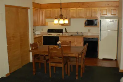 a kitchen with a table and chairs and a refrigerator at Wildwood Inn in Estes Park